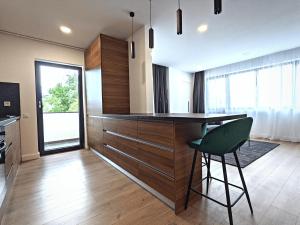 a kitchen with a counter and a green chair at Ira Premium Apartment Cluj in Cluj-Napoca