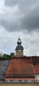a building with a clock tower on top of a roof at Maison de village au coeur des Combrailles in Montaigut-en-Combraille