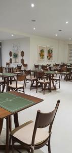 JR Hotel Marilia في ماريليا: غرفة مليئة بالطاولات والكراسي الخشبية