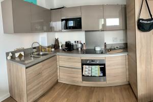 a kitchen with a sink and a stove at Stylish and Chic 1 Bedroom Apartment in Canning Town in London