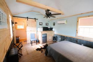 sypialnia z łóżkiem i wentylatorem sufitowym w obiekcie The Outpost w mieście Grand Rivers