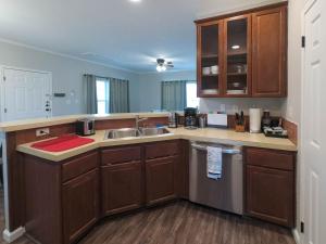 a kitchen with wooden cabinets and a sink at Luxury cottage near lake Belton - WiFi A/C in Belton