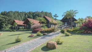 a house with a stone pathway in front of a yard at Pousada Scursel in Ibirama