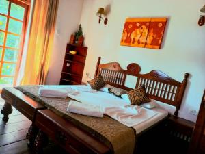 a bedroom with a bed with pillows on it at Veraima Kandy in Kandy