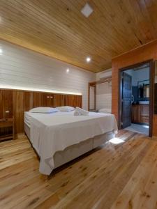 um quarto com uma cama grande e piso em madeira em Pousada Scursel em Ibirama