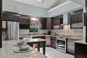 a large kitchen with wooden cabinets and granite counter tops at Centrally located villa, family reunion, amazing outdoor space, pet friendly in Orlando