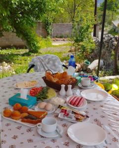 einen Tisch mit Teller mit Lebensmitteln und einem Obstkorb in der Unterkunft Pottery House Sanahin in Alawerdi