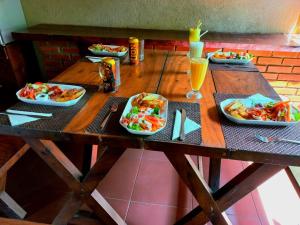 uma mesa de madeira com pratos de comida e bebidas em Veraima Kandy em Kandy