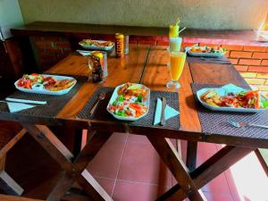 una mesa de madera con platos de comida y bebidas. en Veraima Kandy, en Kandy