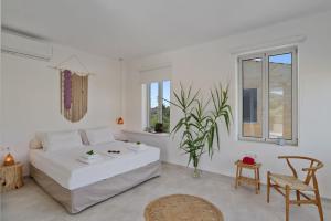 a white room with a bed and a table and chairs at Annassa Suites in Almyrida