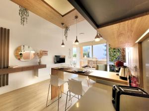 uma cozinha com cadeiras brancas e um balcão com uma mesa em The Valley View Apartments em La Orotava