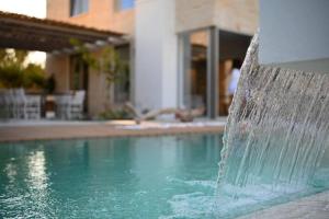 a water fountain in front of a swimming pool at Annassa Suites in Almyrida