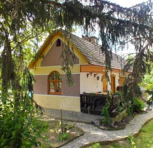 une petite maison jaune et blanche avec un arbre dans l'établissement Ferienhaus Waldhof, à Döbrököz