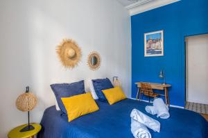 ein blaues Schlafzimmer mit einem blauen Bett und gelben Kissen in der Unterkunft Beautiful air conditioned apartment - Marseille - Welkeys in Marseille