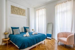 sypialnia z niebieskim łóżkiem i krzesłem w obiekcie Appartement Armény - Welkeys w Marsylii