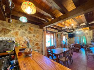 cocina y comedor con mesas y sillas de madera en HOTEL RURAL LA HUERTA en Montejo de la Vega de la Serrezuela