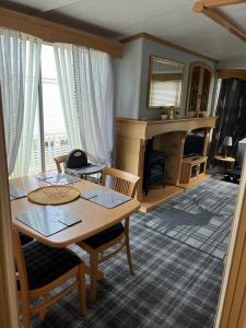 uma sala de estar com uma mesa e uma lareira em 47 Lochview em Stranraer