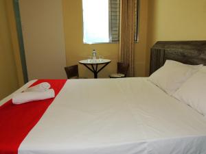 um quarto com uma cama com uma toalha vermelha em Hotel São Judas - Próximo a Expo São Paulo em São Paulo