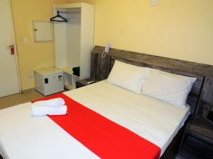 1 dormitorio con 1 cama con manta roja y blanca en Hotel São Judas - Próximo a Expo São Paulo, en São Paulo