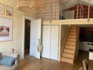 a loft conversion with a staircase and a living room at Appartement cosy au cœur de la ville d’été in Arcachon