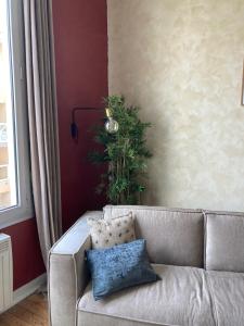 uma sala de estar com um sofá e uma planta em Appartement cosy au cœur de la ville d’été em Arcachon