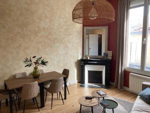 uma sala de estar com uma mesa e uma lareira em Appartement cosy au cœur de la ville d’été em Arcachon