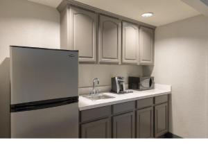 a kitchen with a refrigerator and a sink at Holiday Inn & Suites Orlando SW - Celebration Area, an IHG Hotel in Orlando