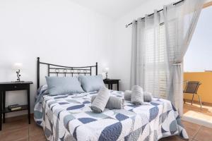 - une chambre dotée d'un lit avec une couverture bleue et blanche dans l'établissement Los Majos Fuerteventura, à Tarajalejo