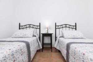 a bedroom with two beds and a table with a lamp at Los Majos Fuerteventura in Tarajalejo +26 photos