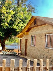 a wooden fence in front of a building with a picnic table at Cabañas CheRu 5 in Posadas