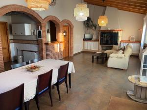cocina y sala de estar con mesa y sillas en Molí den burch, en Santa Eulàlia de Ronçana