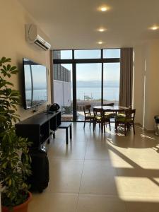 a living room with a table and a large window at Follow Sea Villa in Sowayma