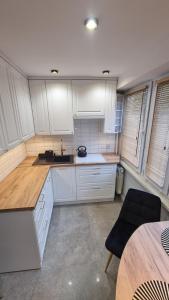 cocina con armarios blancos y encimera de madera en Apartament ZACISZE, en Jarosław