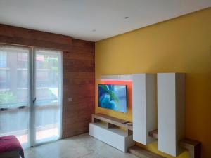 a living room with a tv on a wall at La Selva Incantevole Appartamento in Colazza