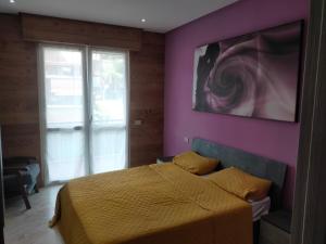 a bedroom with a bed and a purple wall at La Selva Incantevole Appartamento in Colazza