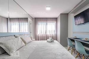 a bedroom with a large bed and a table and chairs at 17- Studio Perfeito para casal! in Curitiba