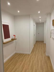un pasillo vacío con paredes blancas y suelo de madera en N&E - Home Celanova AVD San Rosendo, en Celanova