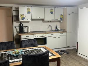 a kitchen with white cabinets and a table and a sink at GOLDSTADT LOUNGE in Pforzheim