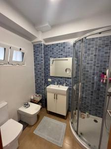 a blue tiled bathroom with a toilet and a shower at Precioso apartamento en 5 minutos de la playa in Playa de las Americas