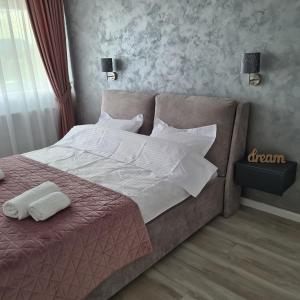 - un lit avec des draps et des oreillers blancs dans une chambre dans l'établissement Panoramic Apartment, à Braşov