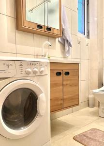 a kitchen with a washing machine and a sink at Nesi apartmenti in Pristina