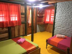 a room with two beds in a cabin at Aparthotel Oleaje in Mompiche