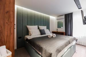 a bedroom with a bed with a green headboard at The White Tree in Pristina