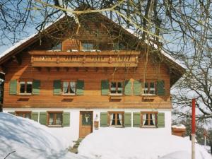 una casa de madera en la nieve en Ferienhof Reichart, en Scheidegg