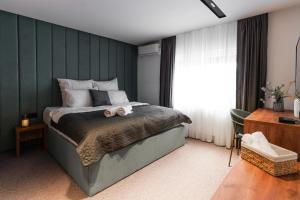 sypialnia z łóżkiem i zieloną ścianą w obiekcie The White Tree w Prisztinie
