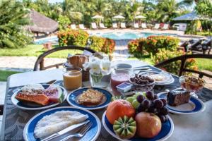 uma mesa com pratos de comida para o pequeno almoço em Hotel Tibau Lagoa em Pipa