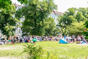 a crowd of people sitting in a park at Spacious apartment in Hemholtzkiez Prenzlauer Berg for 8 People in Berlin