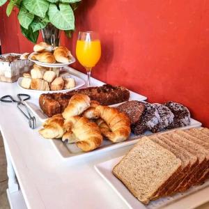 un tavolo con pane e prodotti da forno e un bicchiere di succo d'arancia di Posada Mia Nonna a Villa General Belgrano