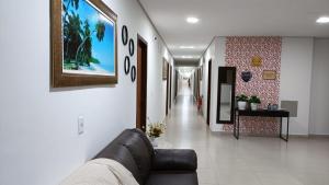 a living room with a couch and a hallway at Bougainville Barreiras in Barreiras