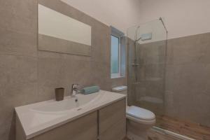 a bathroom with a sink and a toilet and a shower at Sliema - 2 mins from the Beach in Sliema